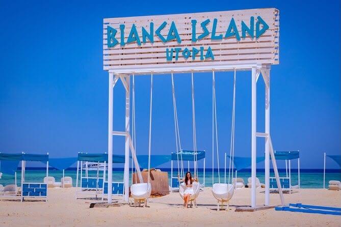 Bianca Island sign above beach swings on the white sand