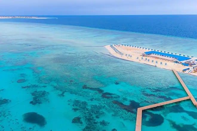 Aerial view of the Bianca Island beach and pier over turquoise reef water