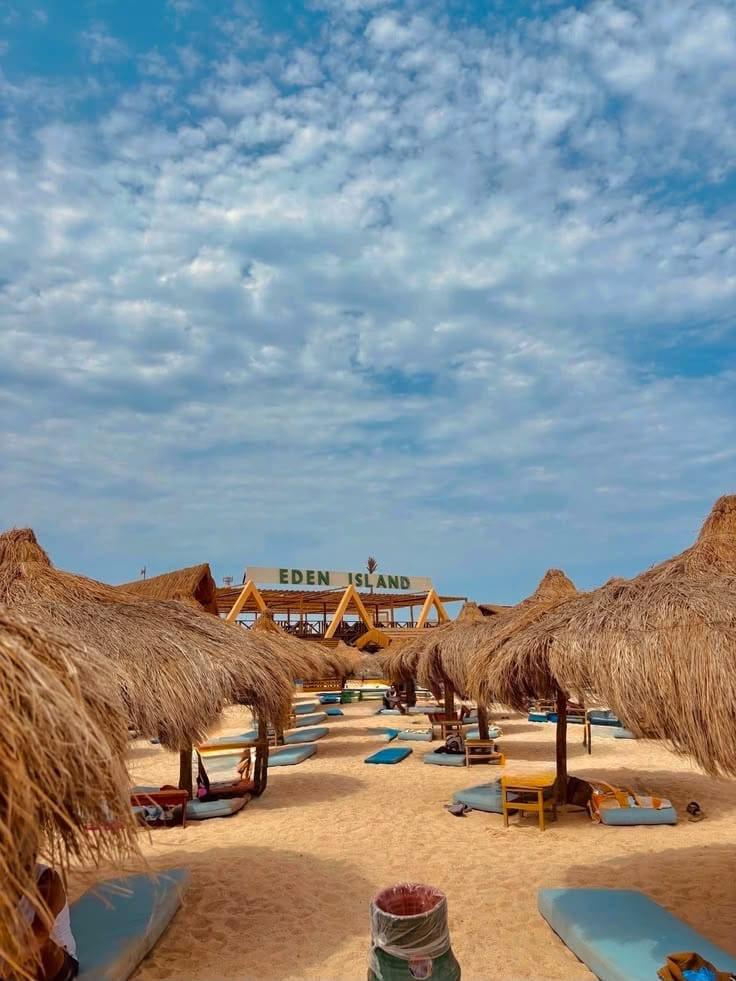 Straw parasols and loungers on the Eden Island beach under a blue sky