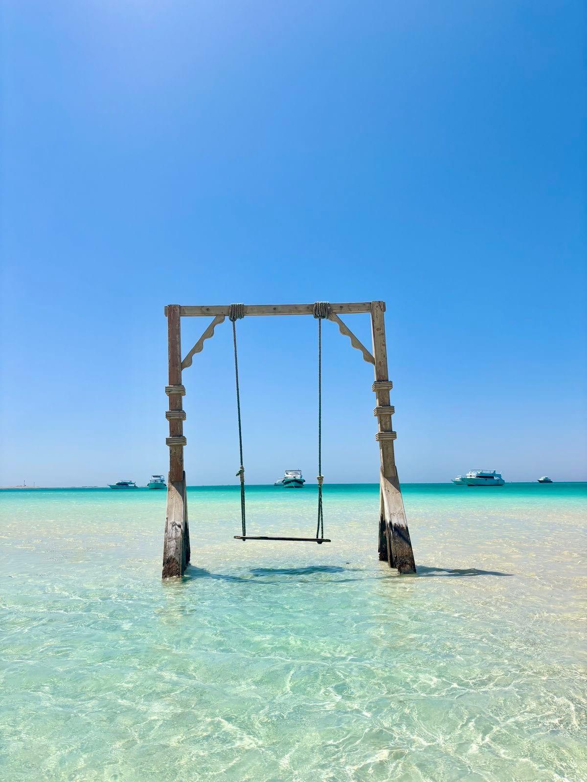 Wooden swing standing in the shallow turquoise water at Orange Bay