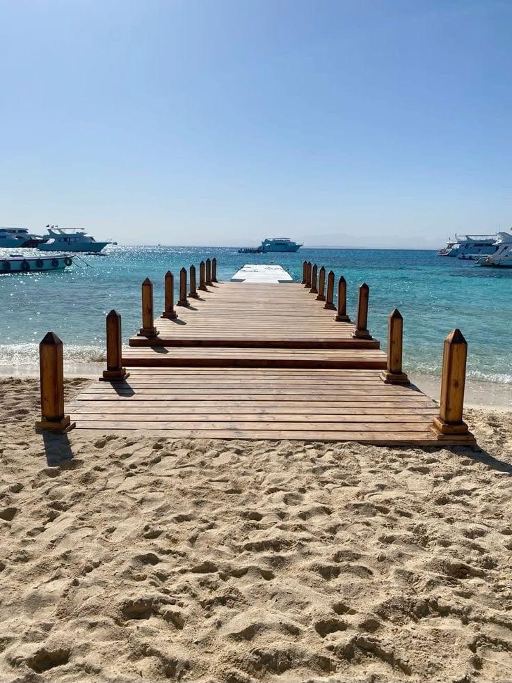 Wooden jetty stretching from the sand into the sea at Paradise Island