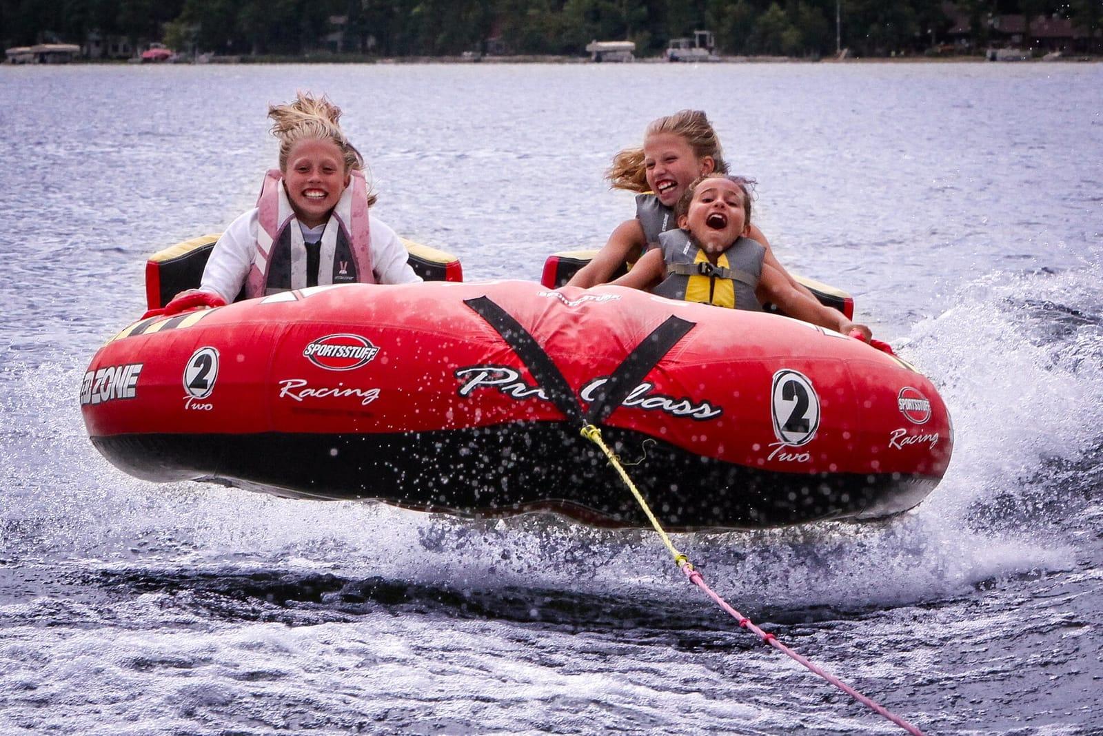 Two riders on a red towable inflatable