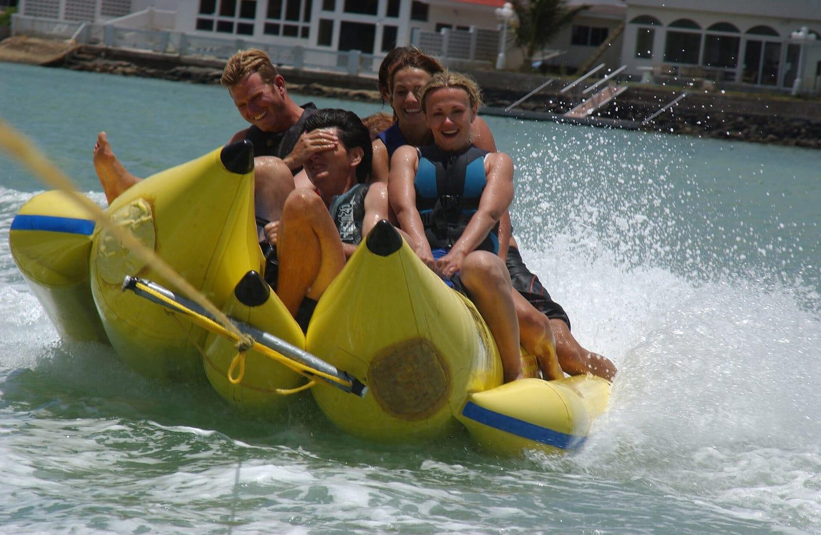 Riders on a towed inflatable ride across the water